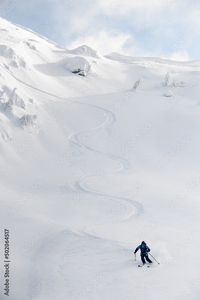 Great view on snowboarder riding down the untouched powder snow.