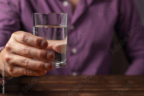 Man drinking from a glass of water. Health care concept photo, lifestyle, close up