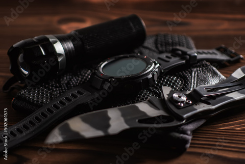 Everyday carry EDC items for men in black color - flashlight, watch and knife. Survival set. Minimal concept.