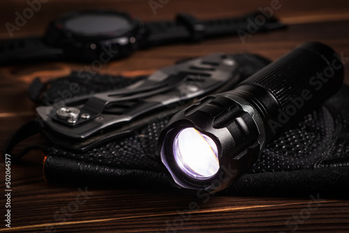 Everyday carry EDC items for men in black color - included flashlight, watch and knife. Survival set. Minimal concept.