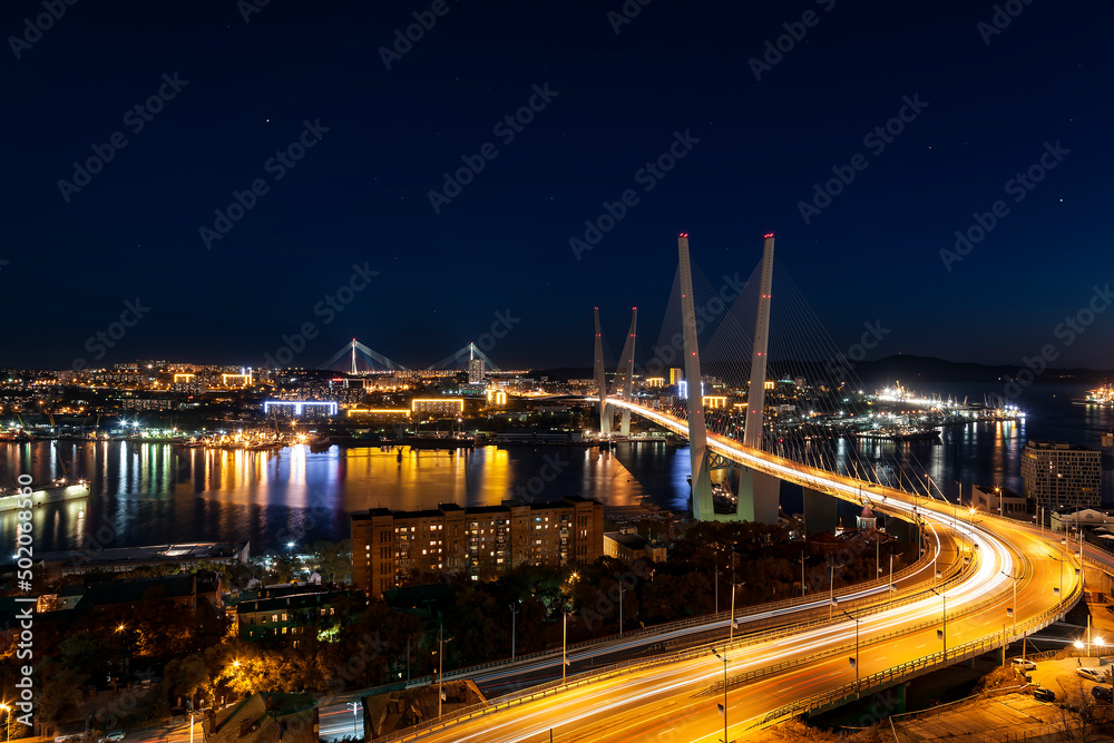 Night Vladivostok. Top view of the city, Golden bridge, Golden Horn bay, and the bridge Russian on the horizon in night illumination. Far East, Russia