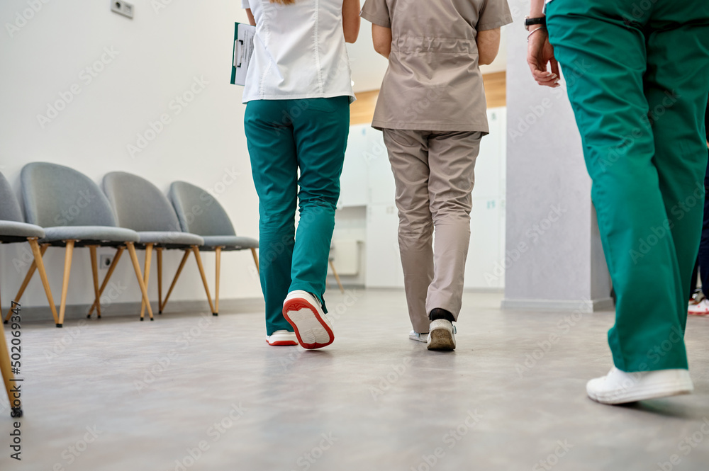 Hospital corridor with walking doctors cropped shot Hospital corridor with walking doctors cropped shot