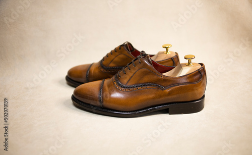 men's classic shoes made of brown leather, with laces, on a light background. Fashionable, stylish shoes, own tannery, the ruin of a small business.