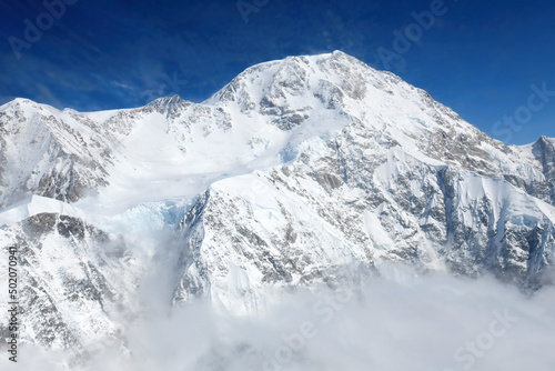Denali, the tallest mountain in North America, rises above the clouds in the Alaska Range.