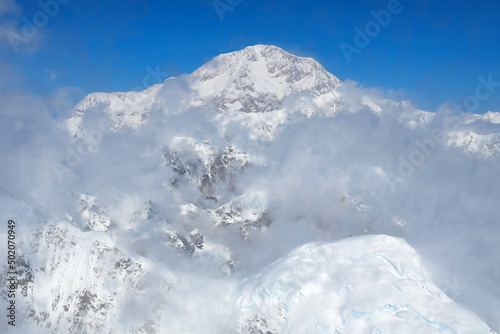 Denali, the tallest mountain in North America, rises above the clouds in the Alaska Range.