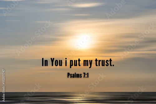 Bible verse taken from Psalms 7:1 - In You i put my trust. With blurry sunset beach background in digital motion effect.