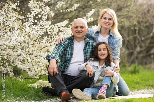 Three generation family sitting outside in spring nature photo