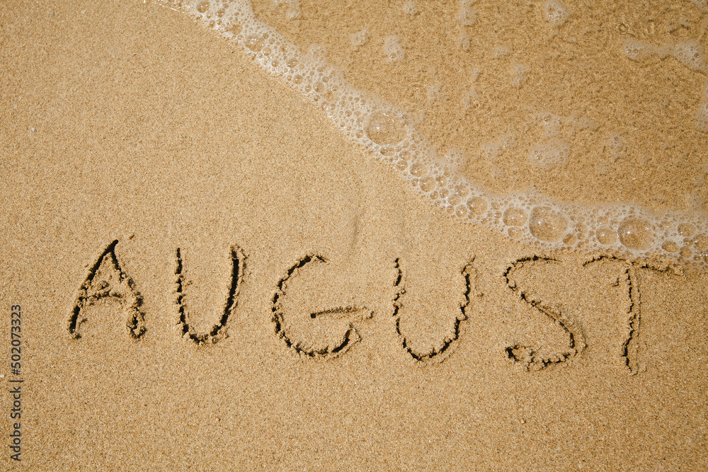 Fototapeta premium August - handwritten on the soft beach sand.