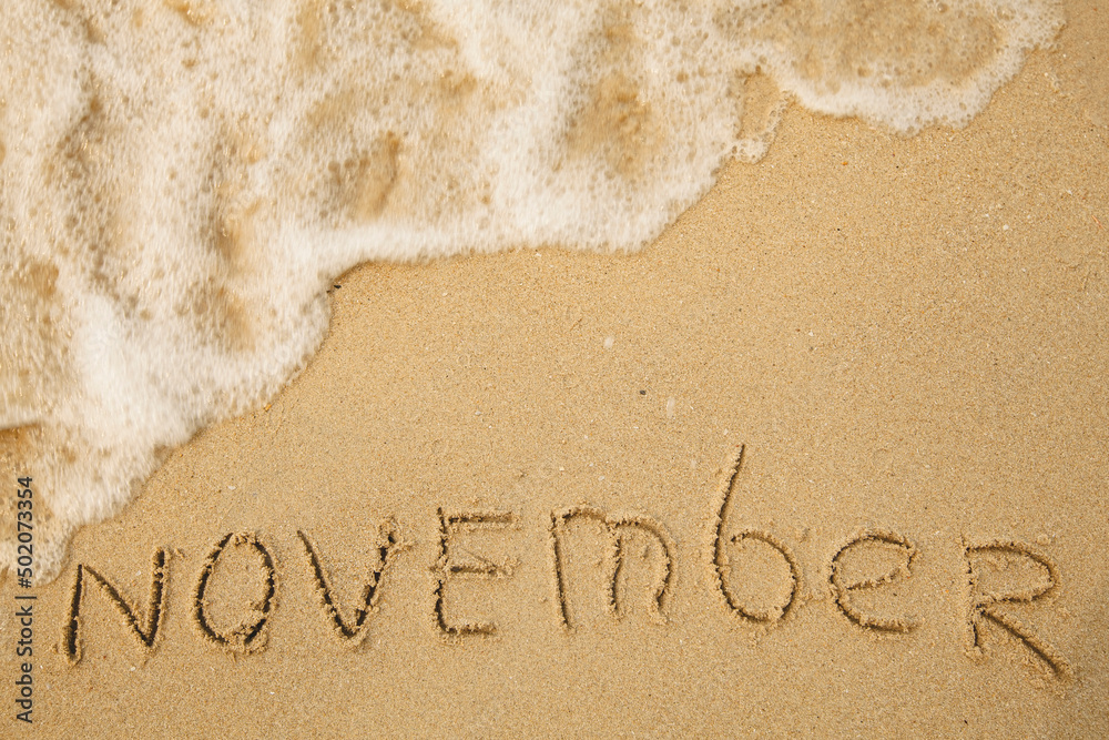 Fototapeta premium November - handwritten on the soft beach sand.