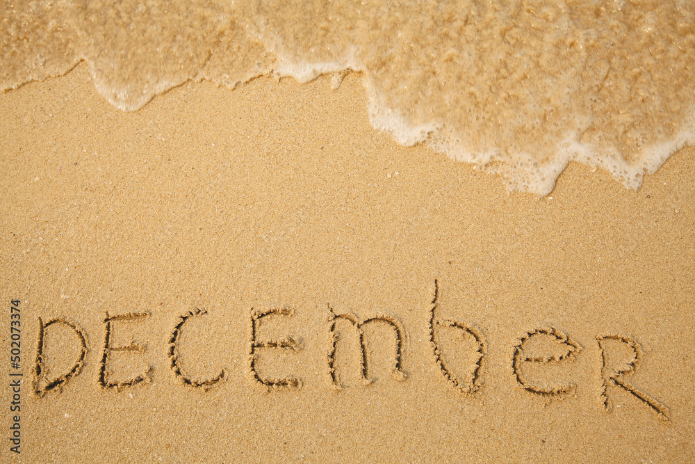 Fototapeta premium December - handwritten on the soft beach sand.