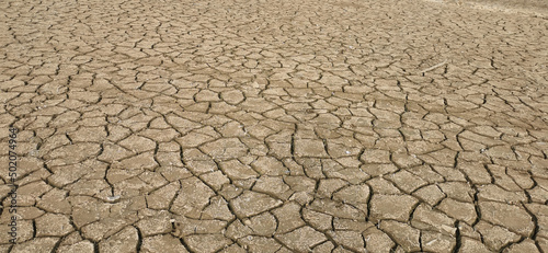 Fotografiet Dry riverbed, with arid and cracked soil because of drought, due to climate chan