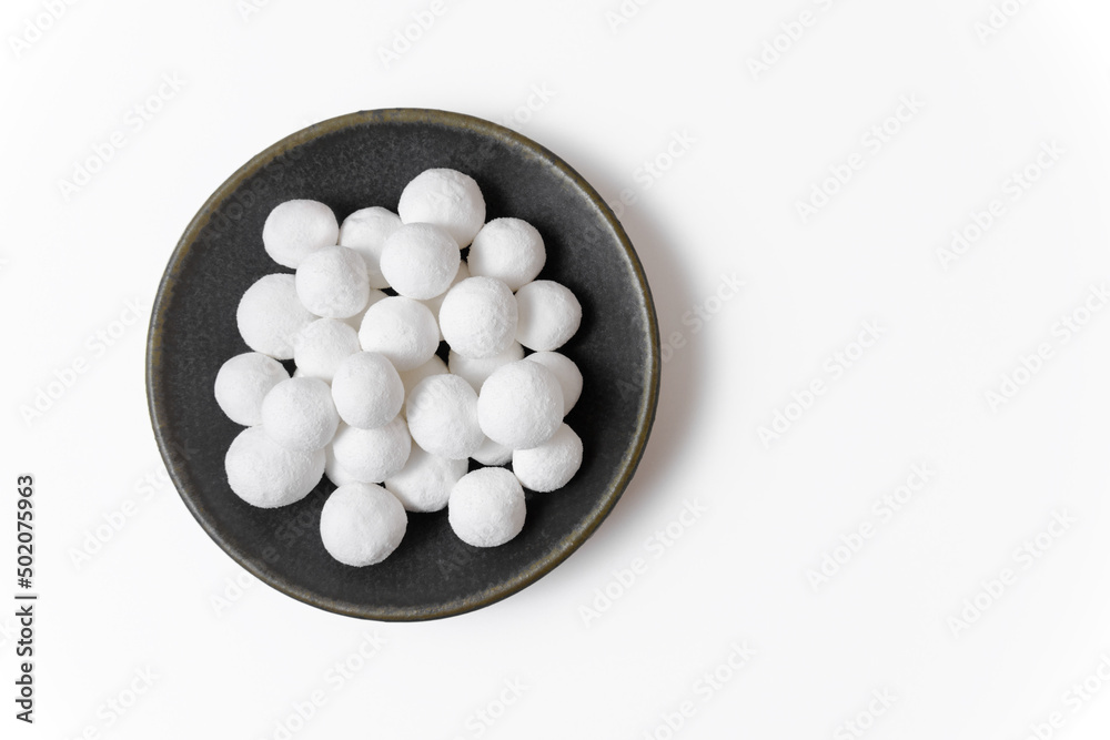 White delicious sugar balls in a gray plate isolated on a white background. Close-up, copy space, top view. White delicious sugar balls in a gray plate isolated on a white background. Close-up, copy space, top view.