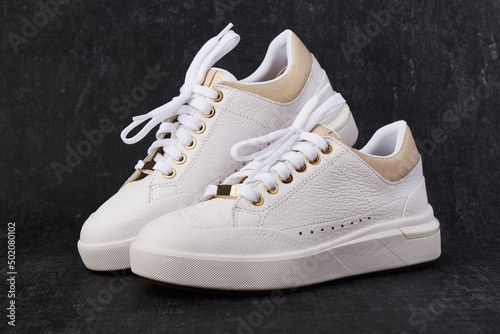Stylish leather sneakers on dark background, casual shoes
