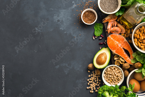 Fototapeta Naklejka Na Ścianę i Meble -  Food sources of omega 3 and healthy fats on dark background top view. Vegetables, seafood, nut and seed