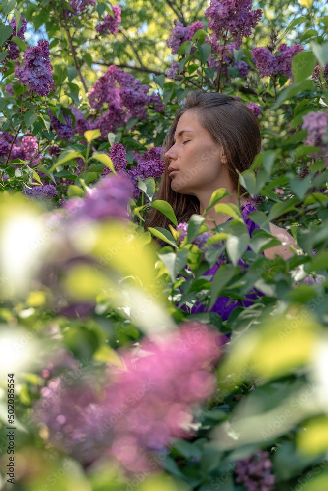 portrait of young woman with long hair outdoors in blooming lilac garden portrait of young woman with long hair outdoors in blooming lilac garden