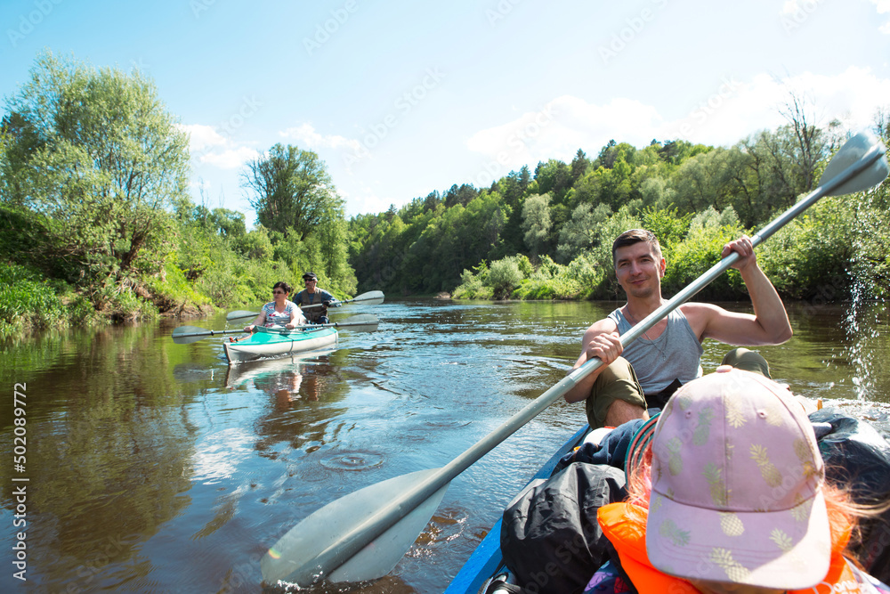 Family kayak trip. Father and daughter, and elderly couple senior and seniora rowing boat on the river, a water hike, a summer adventure. Eco-friendly and extreme tourism, active and healthy lifestyle Family kayak trip. Father and daughter, and elderly couple senior and seniora rowing boat on the river, a water hike, a summer adventure. Eco-friendly and extreme tourism, active and healthy lifestyle