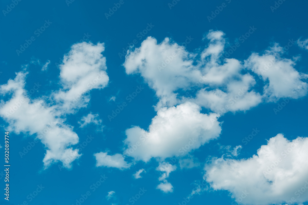 White cumulus clouds in a blue sky. Backgrounds with a pattern of high-beam clouds. Weather, seasonality, ecology, clear sky. Peace 