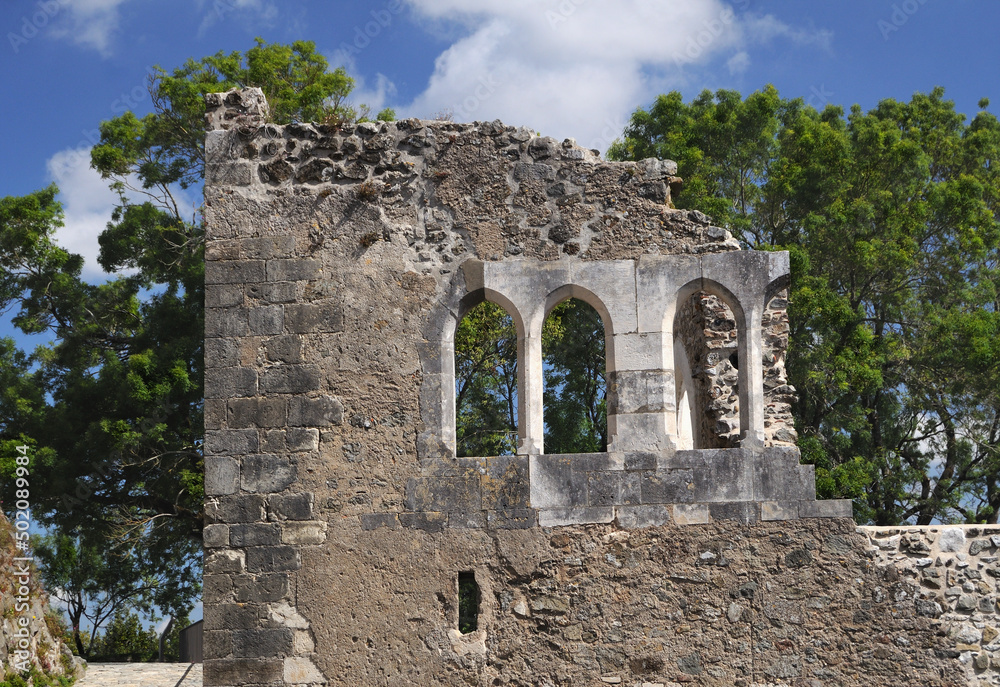 Parede de castelo com janelas em ruínas, arvores por trás, Leiria, Portugal