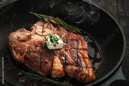 Fotografie, Tablou Cooking t-bone steak in a frying pan with butter
