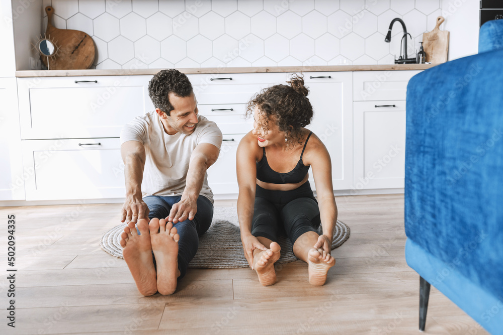 © shunevich - Smiling young sporty couple practicing yoga lesson, doing upward facing dog exercise, Urdhva mukha shvanasana pose, working out, indoor full length, looking at each other on the apartment floor © shunevich - Smiling young sporty couple practicing yoga lesson, doing upward facing dog exercise, Urdhva mukha shvanasana pose, working out, indoor full length, looking at each other on the apartment floor