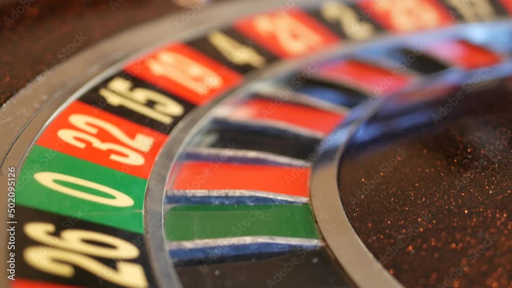Ball on wooden french roulette table in casino. Wheel spinning, turning or rotating. Odd and even numbers, black, red and zero sectors. Bets in game of chance. Money playing, gambling or risky betting