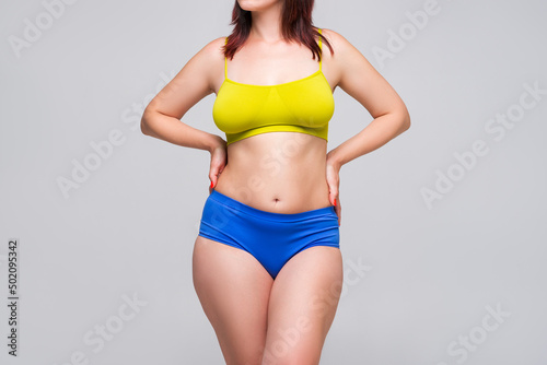 Beautiful sexy woman in colorful underwear on gray background, perfect female body