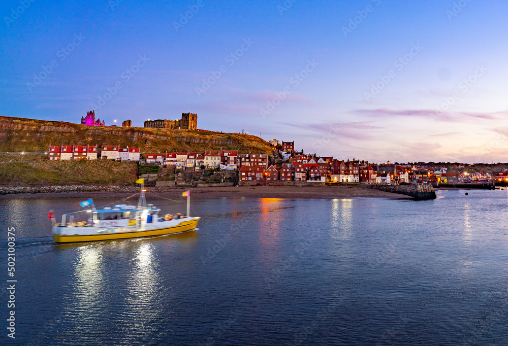 Whitby Harbour at twilight with boat.