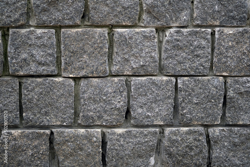 Gray stone wall. Square bricks fence. Abstract pattern of stone mosaic. Taupe Stone wall background texture.
