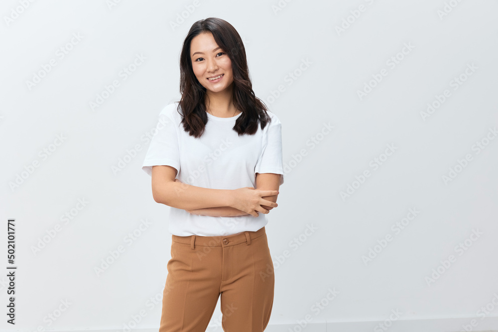 Lovely pretty happy joyful cute Asian young female in white basic t-shirt smiling at camera posing isolated on over white studio background. The best offer for ad. People Lifestyle concept Lovely pretty happy joyful cute Asian young female in white basic t-shirt smiling at camera posing isolated on over white studio background. The best offer for ad. People Lifestyle concept