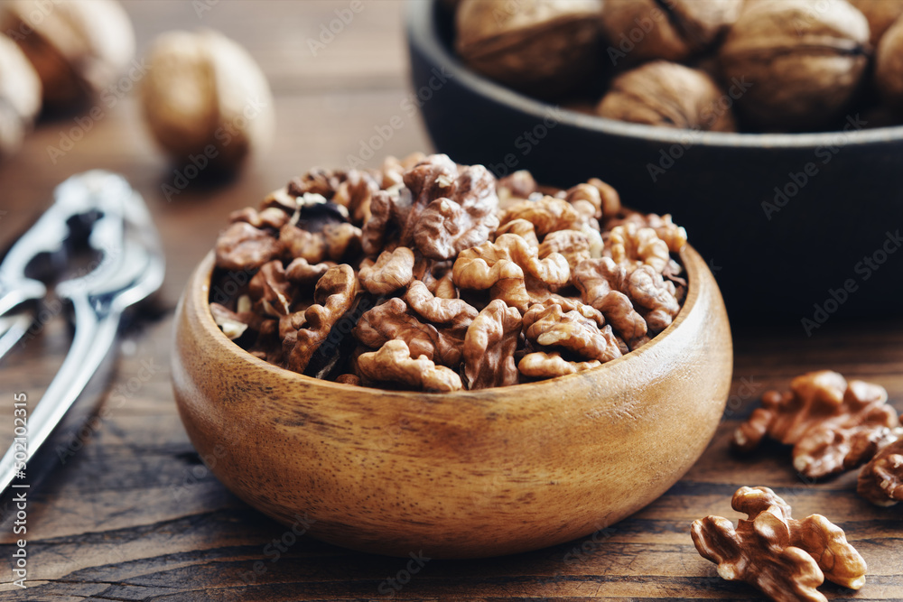 Shelled walnuts, nutcracker and bowl of nuts on kitchen table. Shelled walnuts, nutcracker and bowl of nuts on kitchen table.