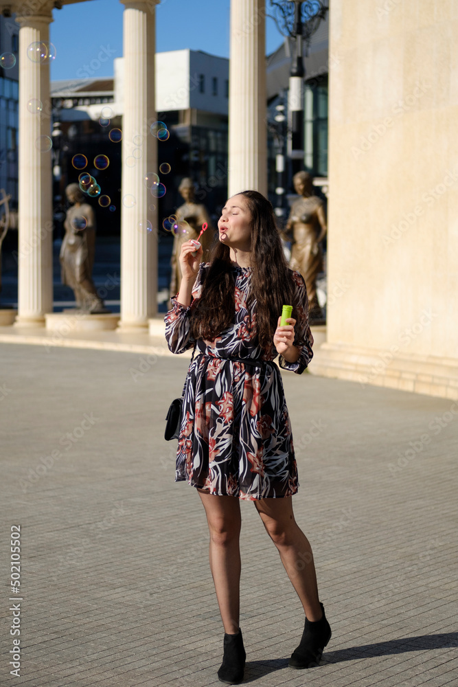 Young lady makes soap bubbles