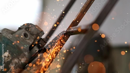 Grinding works with smooth equipment for steel metals, iron, sparks in a heavy industry plant close-up indoors. Welding of thermal parts by a professional worker using a grinder. Slow motion
 photo