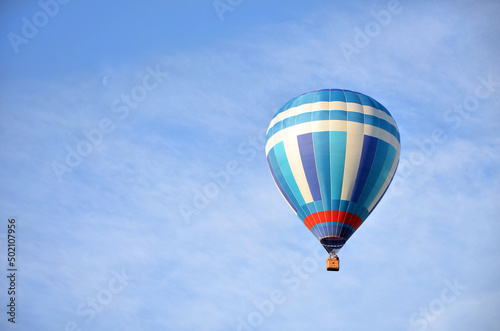 beautiful blue and white hot air balloon in cloudy sky, copy space