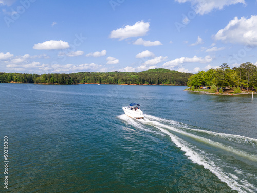 Ski boats at full throttle on an empty lake. Large wake waves behind speed boats.