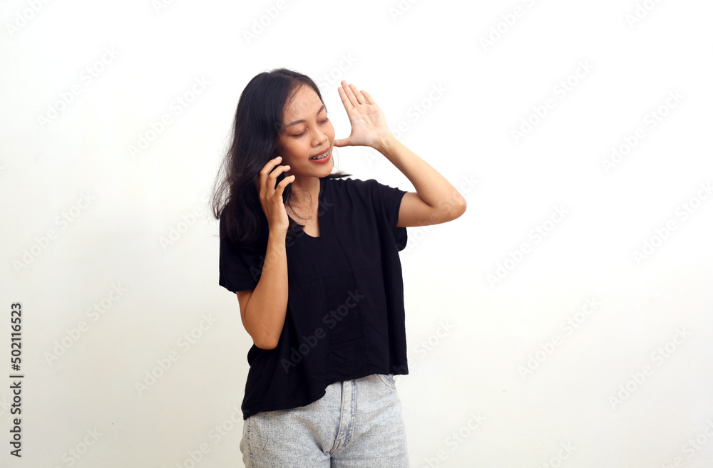 Asian young woman standing while closing her eyes. Isolated on white background