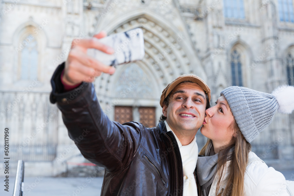 Smiling couple man and woman in the historic center taking selfie