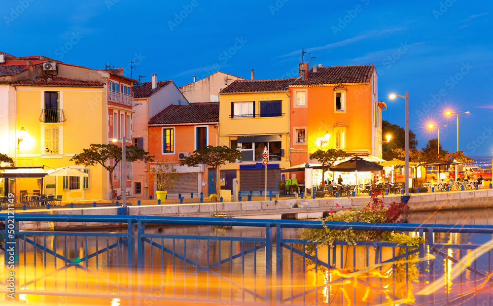 Obraz premium Picturesque evening view of coastal town of Martigues divided by canals with colorful residential buildings along waterfronts in summer, France