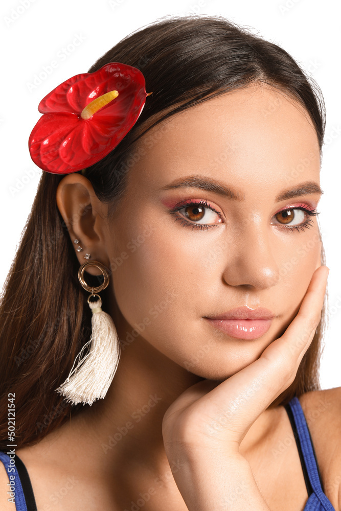 Naklejka premium Portrait of young woman with anthurium flower in her hair on white background
