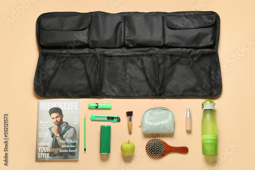 Travel organizer with different things and bottles of drink on color background