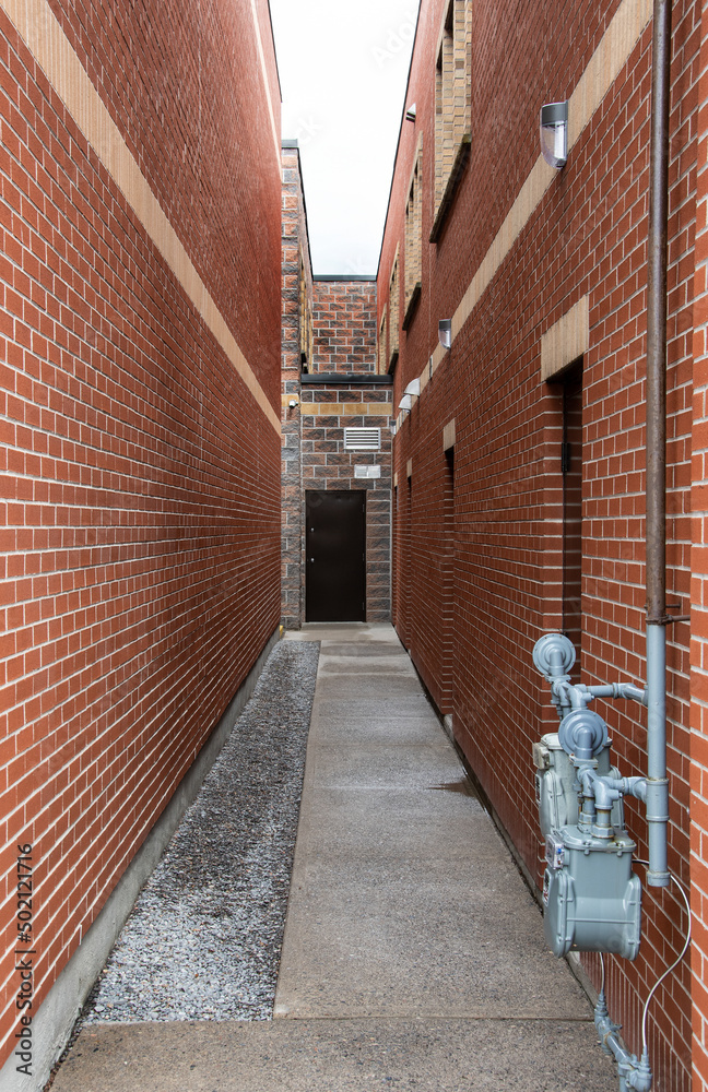 alleyway between two brick walls with door at the end