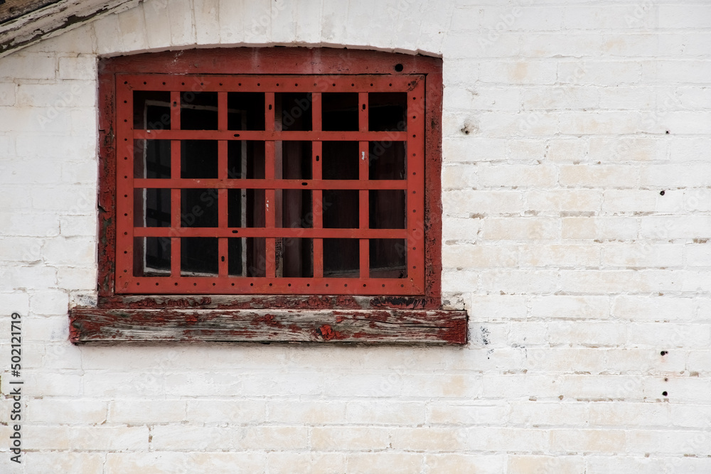 old window with red steel bars