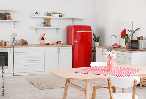 Pink vase with flowers on d...