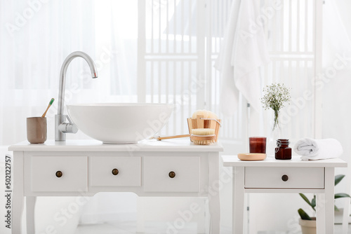 Different bath supplies and modern sink in bathroom interior