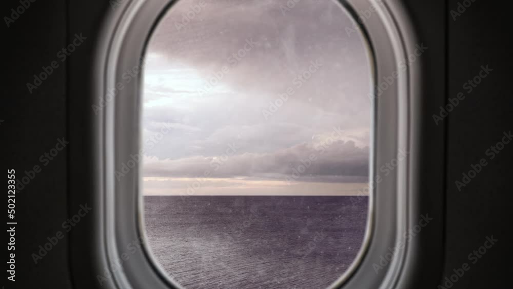Window view from plane flying through turbulence over the ocean with lightning strikes and stormy sky Window view from plane flying through turbulence over the ocean with lightning strikes and stormy sky