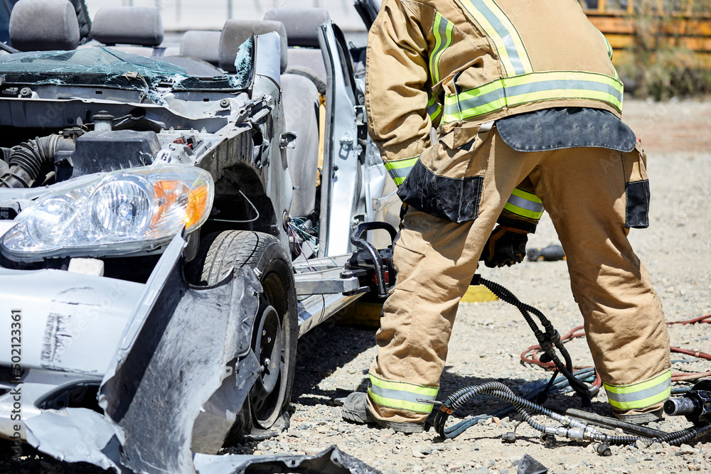 Fire Fighters using the Jaws of Life to dismantle a car Fire Fighters using the Jaws of Life to dismantle a car