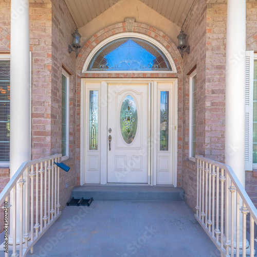 Square Huge single white front door with ornate glass panels and arched transom window