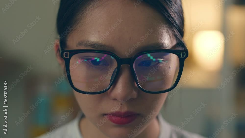 Stock trading woman wearing eyeglasses looking at computer screen reflecting in glasses analyzing stock trading graph. Close up of eyes refection Stock trading woman wearing eyeglasses looking at computer screen reflecting in glasses analyzing stock trading graph. Close up of eyes refection