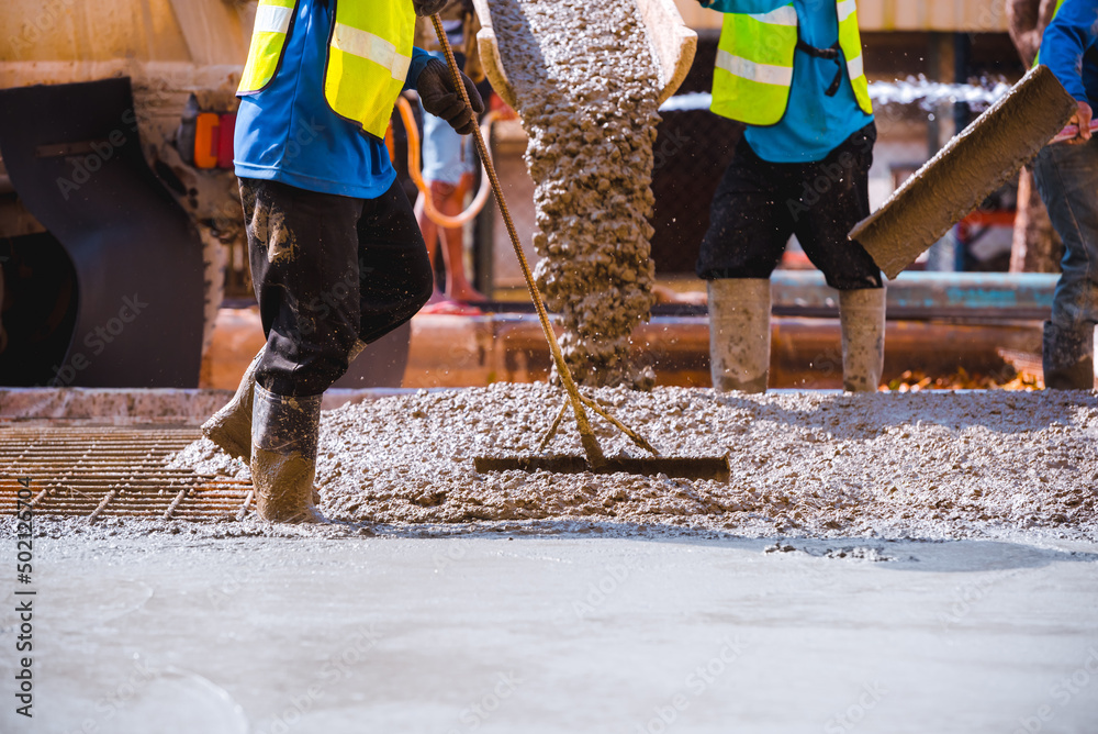 Concrete pouring process. Construction workers are pouring concrete in civil building foundation