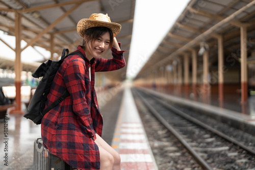 Happy asia woman traveller feeling happiness before go to travel at the train station, summer travel and lifestyle concept