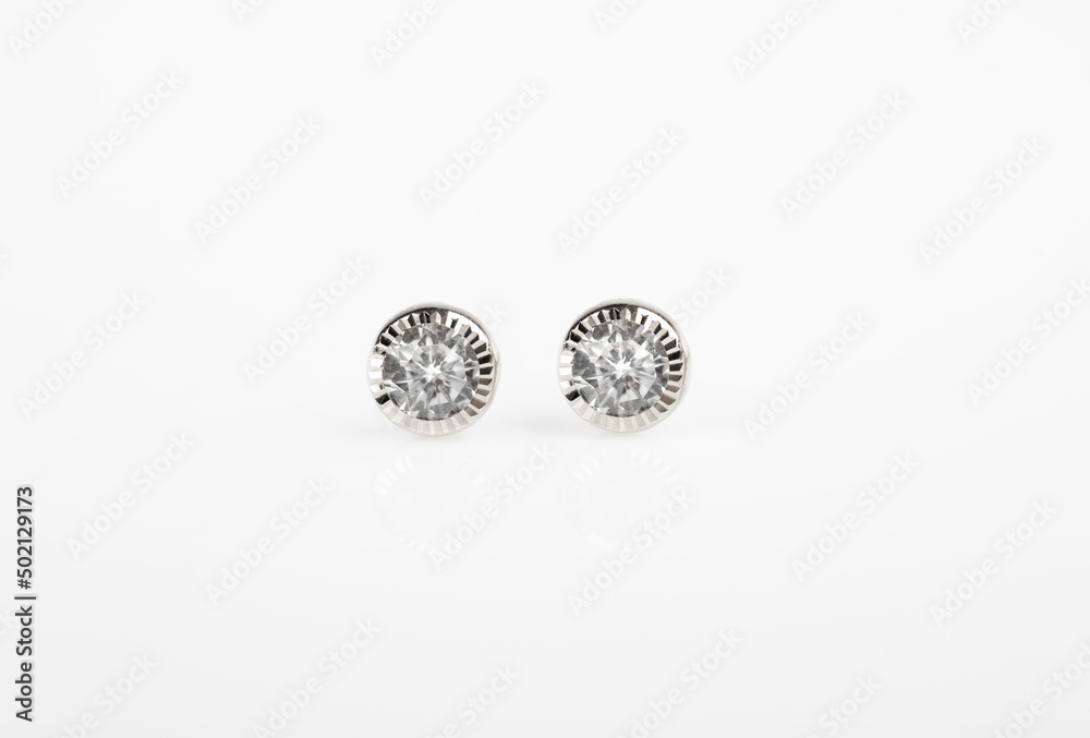 Round silver stud earrings with diamond on white background.